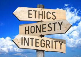 Ethics, honesty, integrity - business concept - wooden signpost